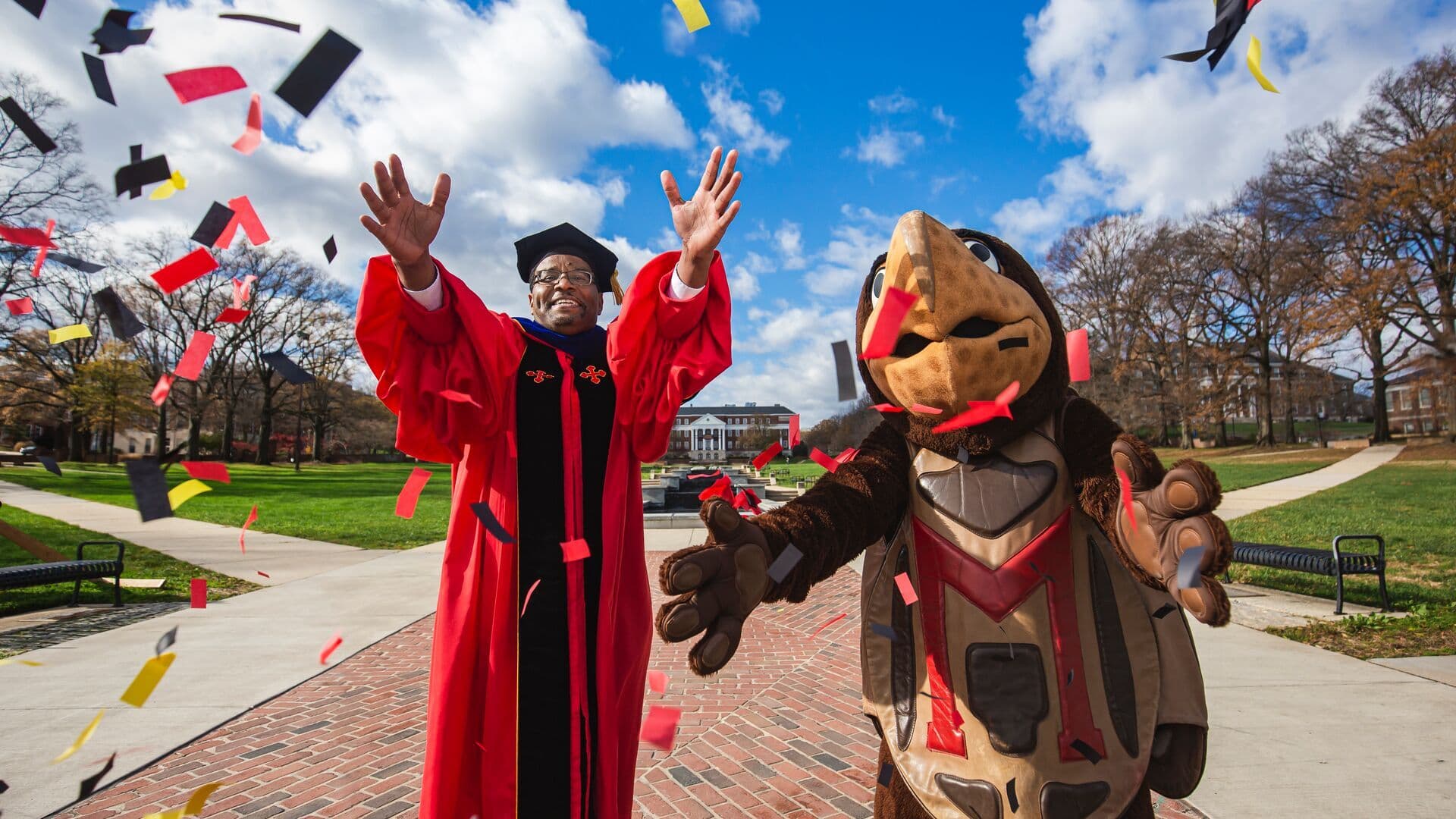 University of Maryland President, Darryl J. Pines, and the school's mascot, Testudo, celebrate and throw confetti.