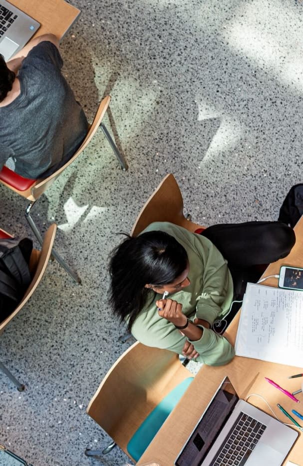 Students studying and reading class notes on a piece of paper