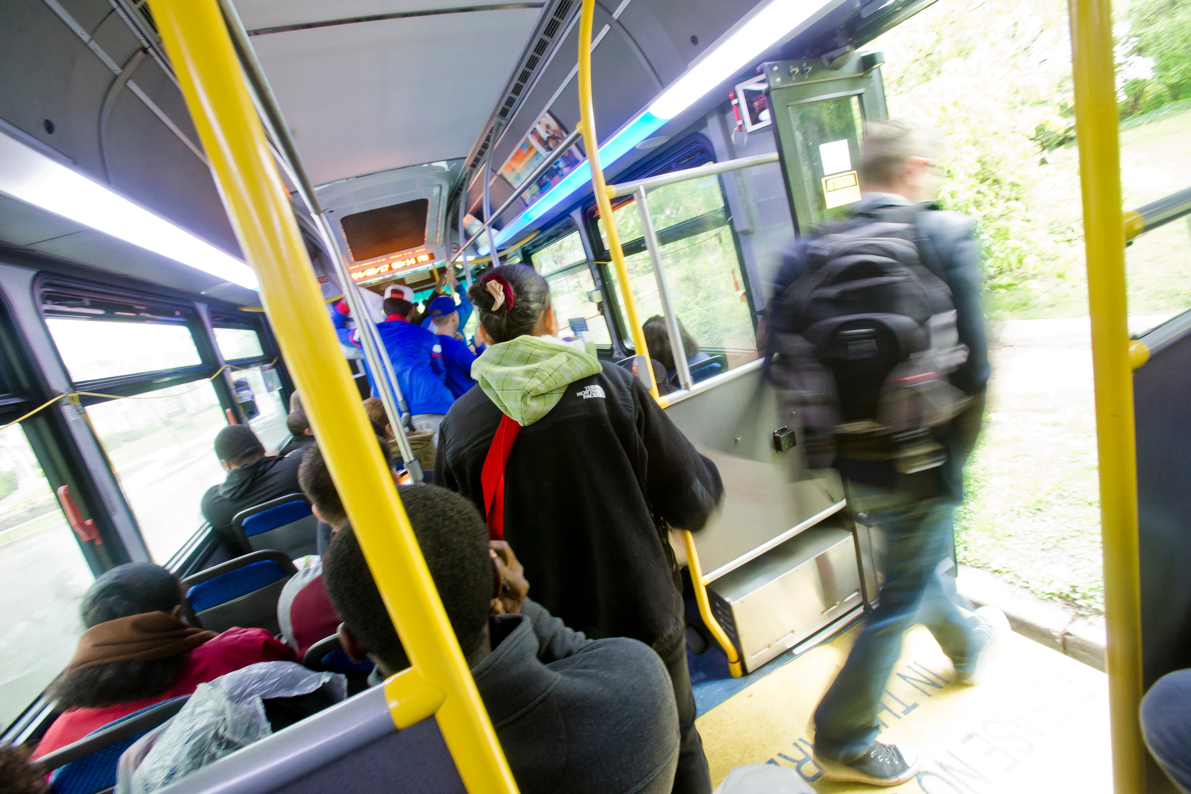 Blurred image of a person getting off of a UMD bus