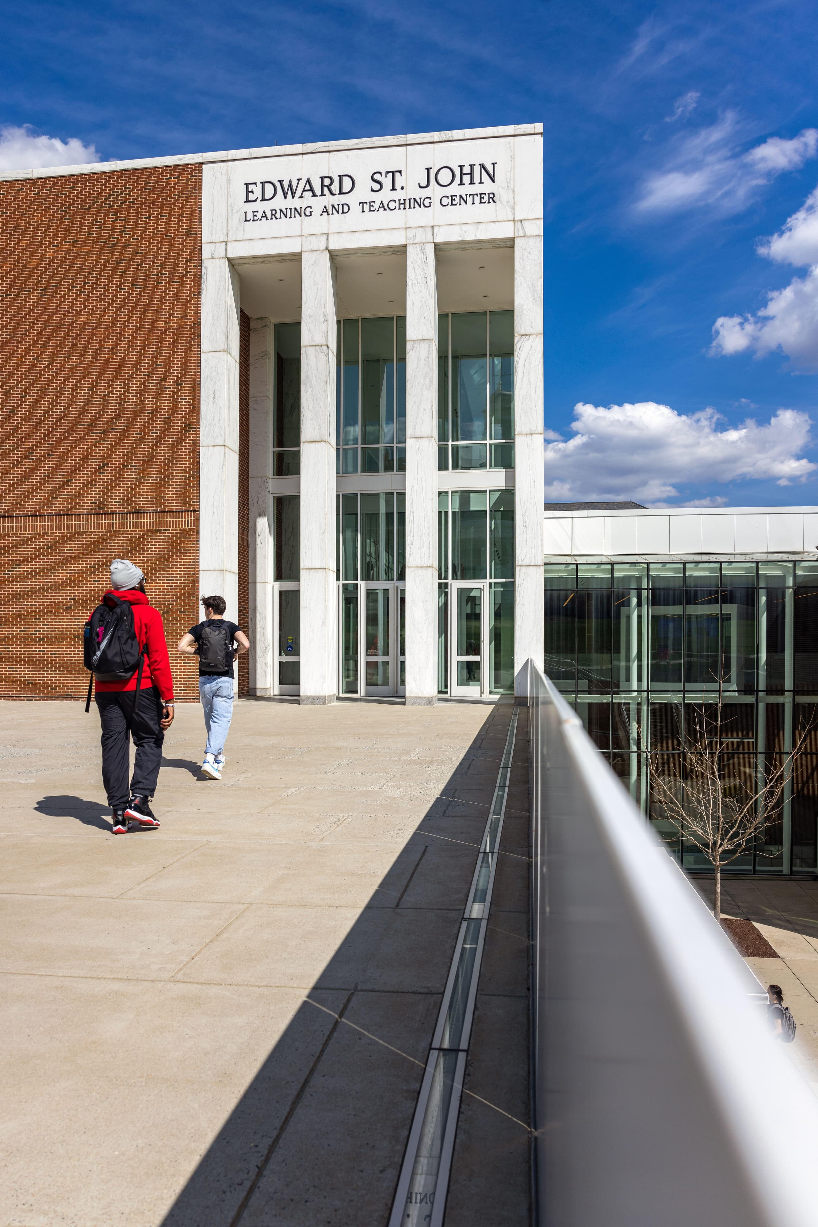Students walking into the Edward St. John Learning and Teaching Center.